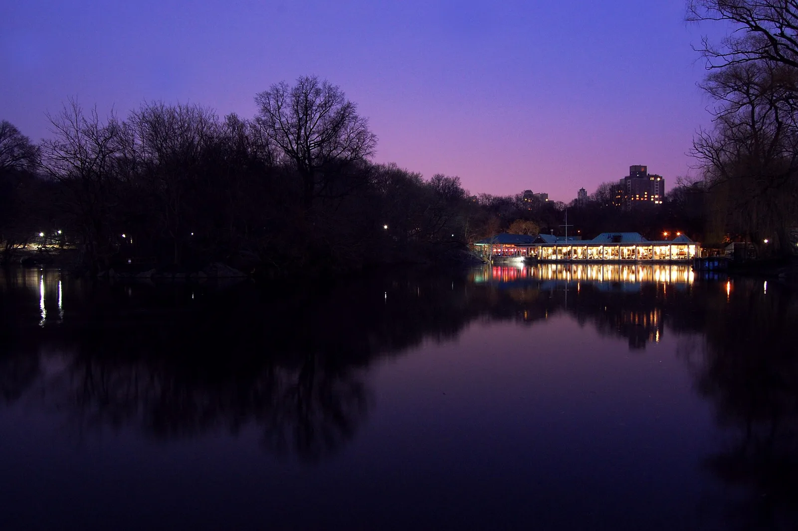 The Loeb Boathouse lit up on the shore of the Lake in Central Park at dusk