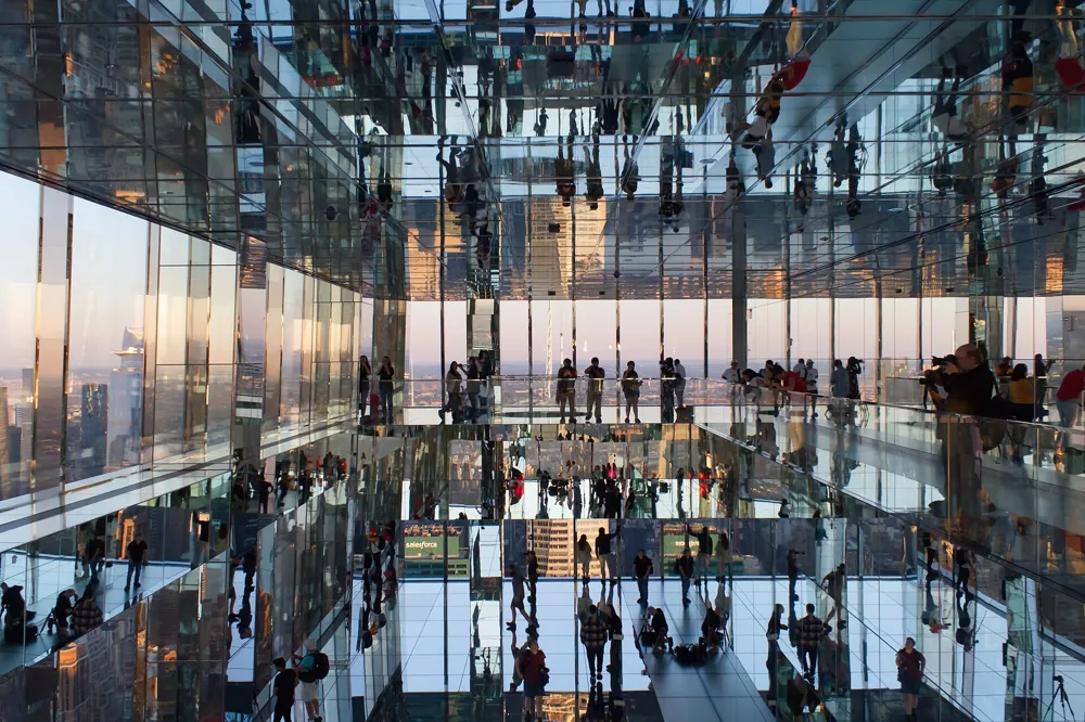 Mirrored room at SUMMIT One Vanderbilt with visitors and city views reflected all around
